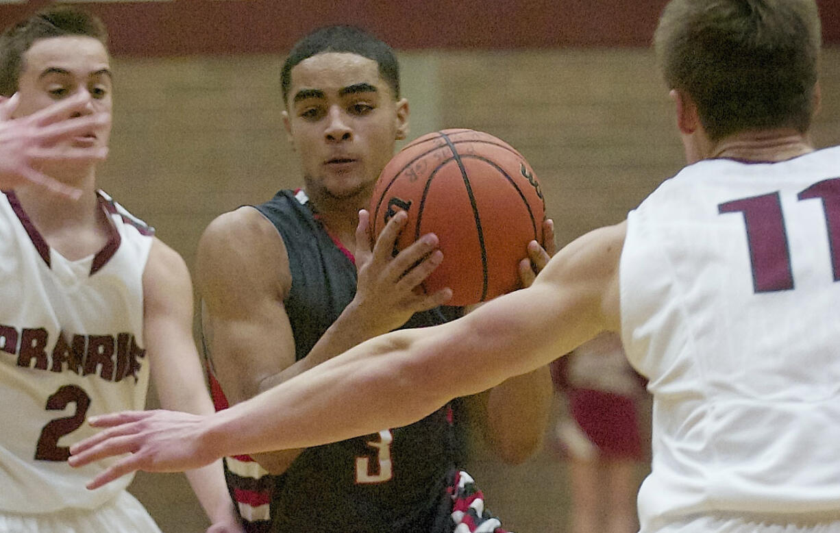 Tre Eisenhut (3) of Fort Vancouver drives to the basket against defenders Palmer Goecke (2) and James Phillips (11) of Prairie in a game Tuesday.