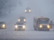 A school bus driver cleans ice off the windshield wipers on the N.E. 179th Street exit from I-5 on Thursday.