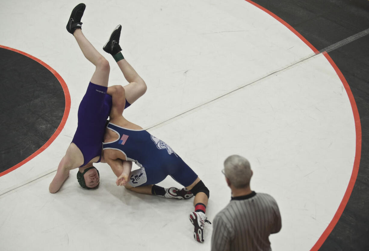 Skyview's Cameron Hutchison, right, turns Heritage High's Andrew McAllister on his head before pinning him during the 4A district wrestling championships at Battle Ground High School on Tuesday February 11, 2014.