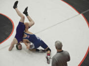 Skyview's Cameron Hutchison, right, turns Heritage High's Andrew McAllister on his head before pinning him during the 4A district wrestling championships at Battle Ground High School on Tuesday February 11, 2014.