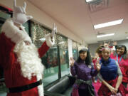 Chris Balduc, left, greets attendees using American Sign Language at a DeafVibe Foundation holiday party on Dec. 13 at their Vancouver office. Balduc is a case worker for the Southwest Washington Center of the Deaf and Hard of Hearing.