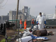 Andrew Newkirk, a mitigation technician of ServiceMaster of Vancouver, searches for biohazards Wednesday morning on West 12th Street, where up to 150 homeless people had been camping.