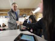 Gov. Jay Inslee, left, and his wife, Trudi, greet McLoughlin Middle School students Lizbeth Martinez, seated at center, and Karol Hoyos, both 14, in Bill Sixour's U.S. history class on Wednesday. They were using tablets to learn about the Underground Railroad.