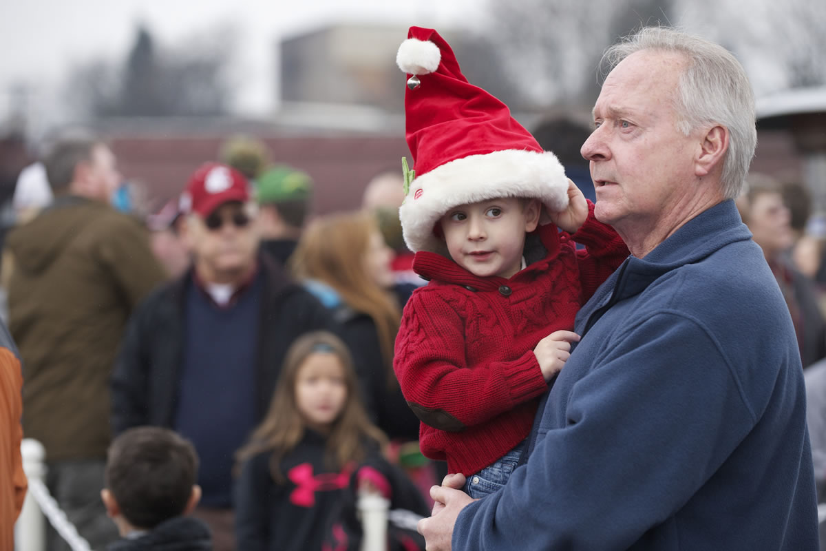 Liam McCann, 3, and his grandfather Larry Grant wait for Santa to arrive Saturday.