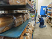 Volunteer June Alba helps organize food at FISH Westside Food Pantry of Vancouver on Monday, the day before the pantry opened at its new, larger location in downtown Vancouver.