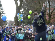 Peter Van Nortwick shows off his touchdown dance as he and other fans gather to show their support of the Seattle Seahawks Saturday morning at Esther Short Park.