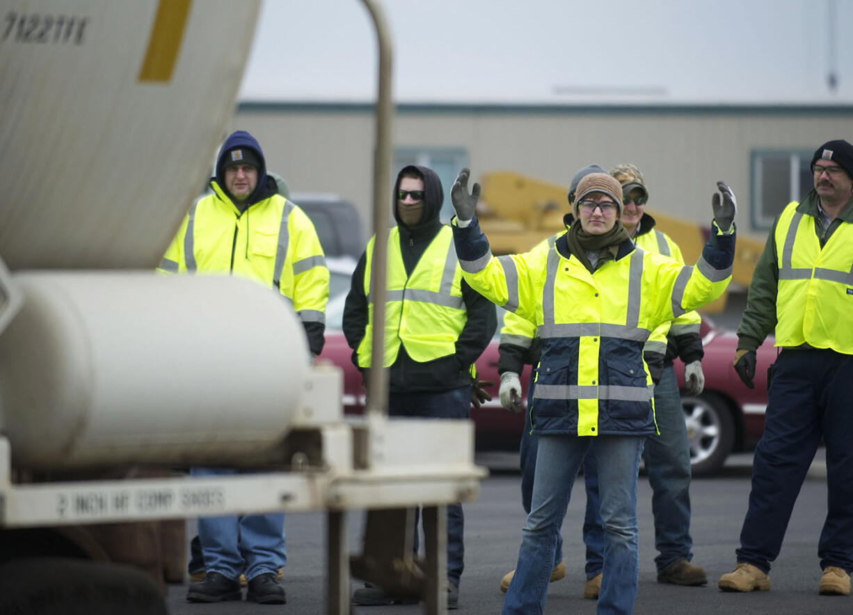 Ana Green, 21, uses her hands to signal a locomotive engineer to back up a train. Green and the other students at Northwest Railroad Institute are learning skills needed to work in the railroad industry.