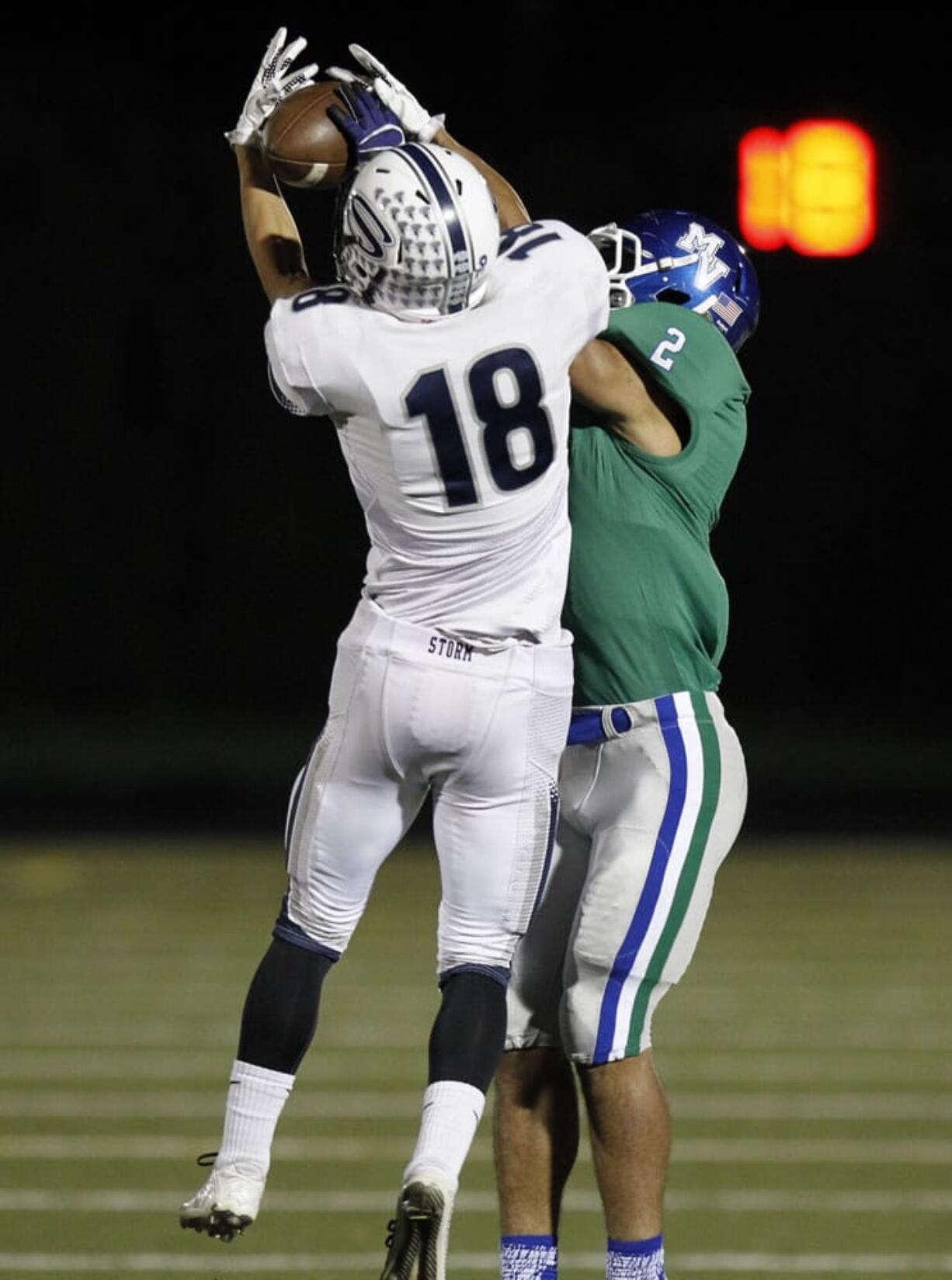 Skyview defensive back Jefferson Kiyasu (18) pulls in an interception against Mountain View wide receiver Preston Jones (2) at 4A GSHL football league tiebreaker between Skyview, Battle Ground, Mountain View.