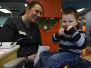 Austin Labrum demonstrates his flossing technique for Christina Beard during a dental visit Thursday at Adventure Dental in Vancouver.