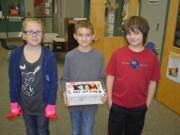 Washougal: Cape Horn-Skye Elementary School fourth-graders Briana Kistner, from left, Aiden Imel and Chase Delp help prepare treats and words of encouragement to be sent to military members serving overseas.