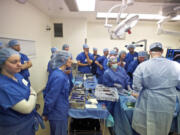 Physical therapists watch Dr. Todd Borus perform a partial knee replacement on a cadaver leg Saturday at Legacy Salmon Creek Medical Center.