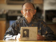 Navy veteran Ed Maresh shows a photo of himself as a 16-year-old sailor in 1943.