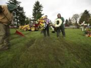 Grounds crew employee Terry Nichols, from left, Funeral Director Scott Bowen and grounds foreman Greg Melum arrange a grave site Nov. 7 at the Garden of Hope portion of Evergreen Memorial Gardens in Vancouver.