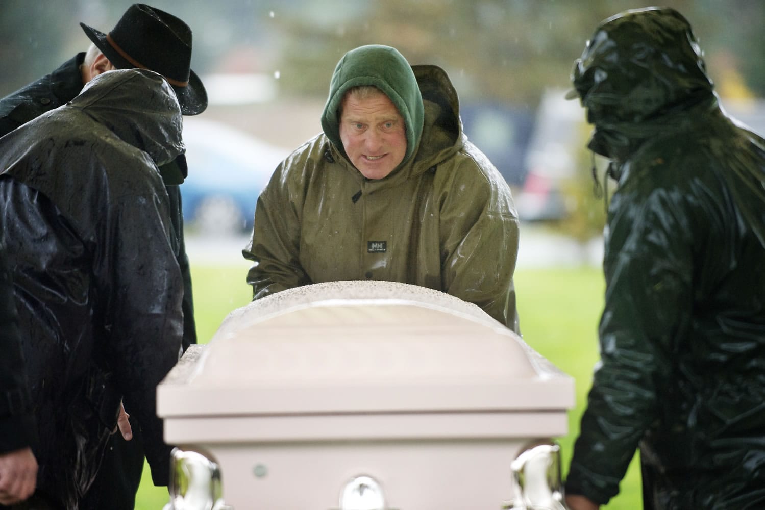 Greg Melum, center, grounds foreman for Evergreen Memorial Gardens cemetery, helps place a casket under a shelter in preparation for an outdoor funeral Nov.