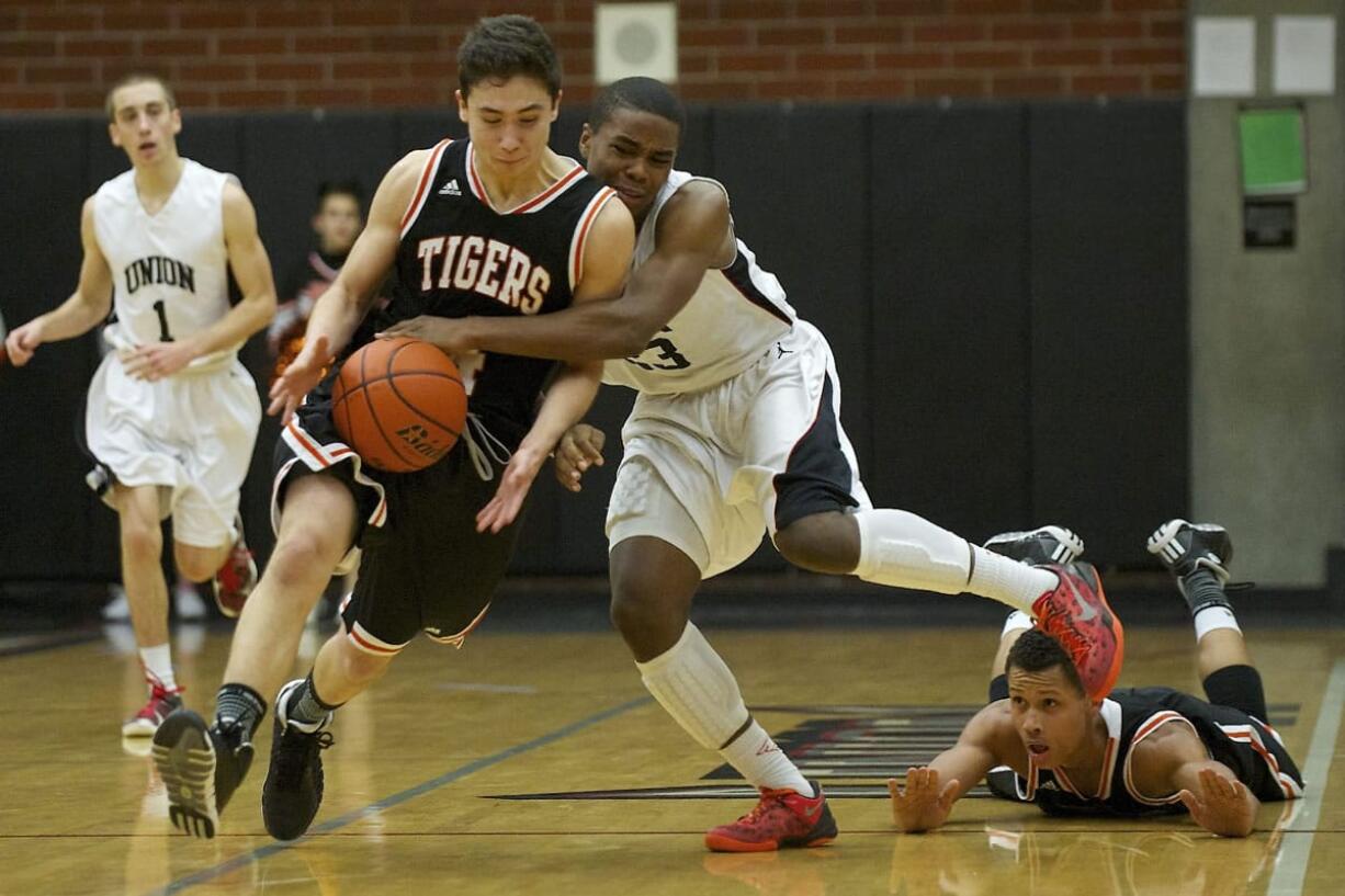 Nate Moring (5) of Battle Ground, left, and Damien Ford (4), far right on court, put half court pressure on Skillful Davis, (23), of Union on Tuesday. Davis was fouled on the play.