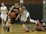 Nate Moring (5) of Battle Ground, left, and Damien Ford (4), far right on court, put half court pressure on Skillful Davis, (23), of Union on Tuesday. Davis was fouled on the play.