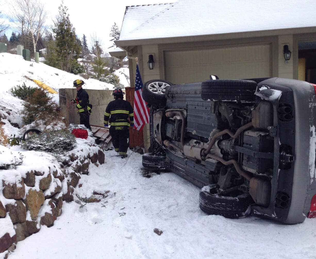 A woman escaped serious injury when the vehicle she was driving slid off the roadway and 20 feet down a hill and landed on its side in a driveway.