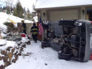 A woman escaped serious injury when the vehicle she was driving slid off the roadway and 20 feet down a hill and landed on its side in a driveway.