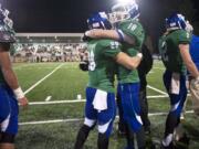 Mountain View's Avi Bharth, right, and Nick Niedermeyer hug late in the fourth quarter against O'Dea in the Class 3A state quarterfinal game at McKenzie Stadium on Friday November 22, 2013.