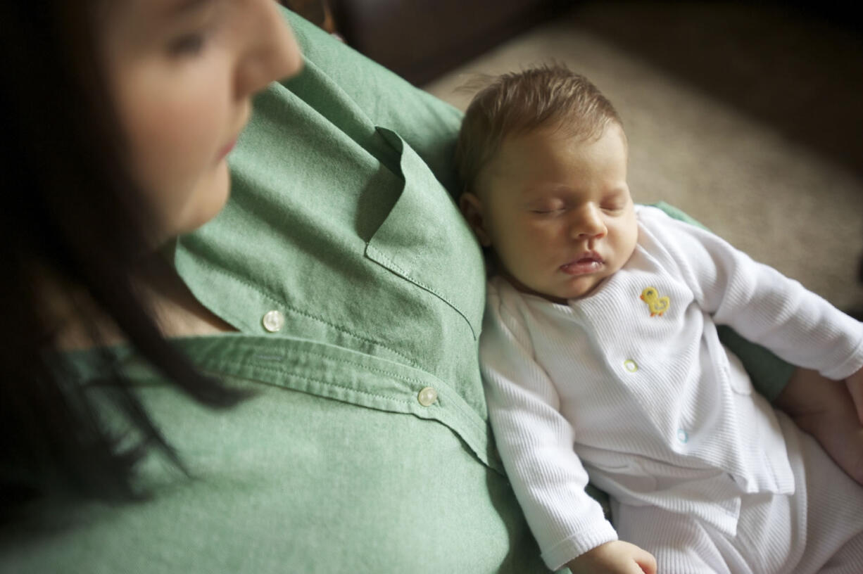 Corena Smith holds her infant daughter, Harper, at her Vancouver home. Nick and Corena Smith spent several hours trying to get  Harper enrolled in Medicaid.