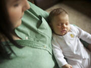 Corena Smith holds her infant daughter, Harper, at her Vancouver home. Nick and Corena Smith spent several hours trying to get  Harper enrolled in Medicaid.