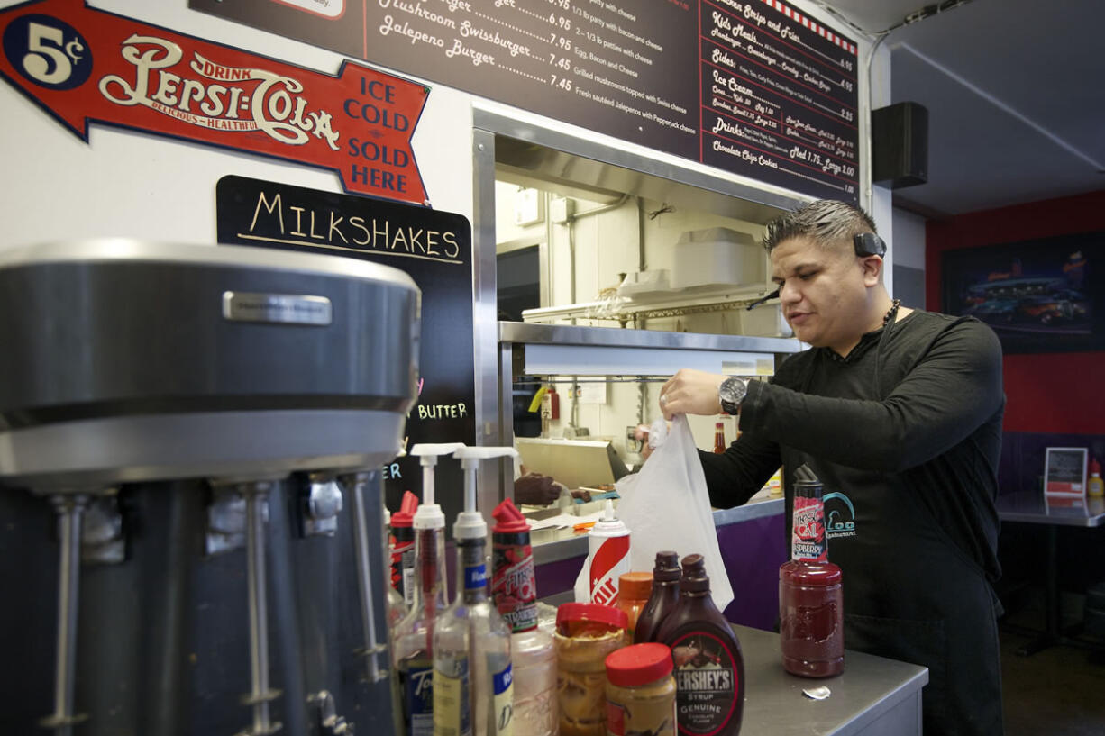 Jorge Estrada, owner of the Igloo Restaurant, bags up a to-go lunch order for a customer. Estrada and his wife Andrea Estrada reopened the longtime local business on Oct.