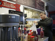 Jorge Estrada, owner of the Igloo Restaurant, bags up a to-go lunch order for a customer. Estrada and his wife Andrea Estrada reopened the longtime local business on Oct.