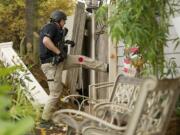 Vancouver police Detective Adam Ruth kicks in a fence during a raid on a chronic problem house in the Hough neighborhood.