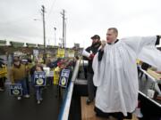 Father Jeremy Lucas of Christ Church Parish of Lake Oswego, Ore., speaks to locked-out Longshore workers from ILWU Local 4 during an Ash Wednesday protest outside the United Grain terminal at the Port of Vancouver.