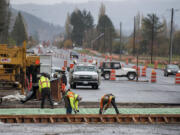 Motorists navigate around construction crews Monday as they continue work to widen state Highway 502 between Interstate 5 and Battle Ground.