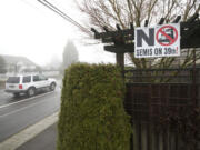 Signs such as this one, photographed Tuesday, have been posted for more than a year by residents who want the city to ban tractor-trailers from West 39th Street.