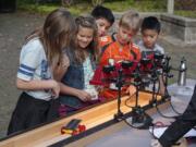 Columbia Valley Elementary School fourth-graders Lily Scholl, from left, Paige Holstad, Victor Jimenez, Payton Holstad and Travis Nguyen take their solar-powered car for a test run Tuesday at the Water Resources Education Center.