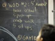 The CrossFit Kids workout for Wednesday evening is outlined on a chalkboard at Industrial CrossFit.