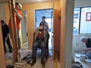 Rocco Tedesco checks on the progress of Home Depot volunteers as they start a project Wednesday to make his home wheelchair accessible.