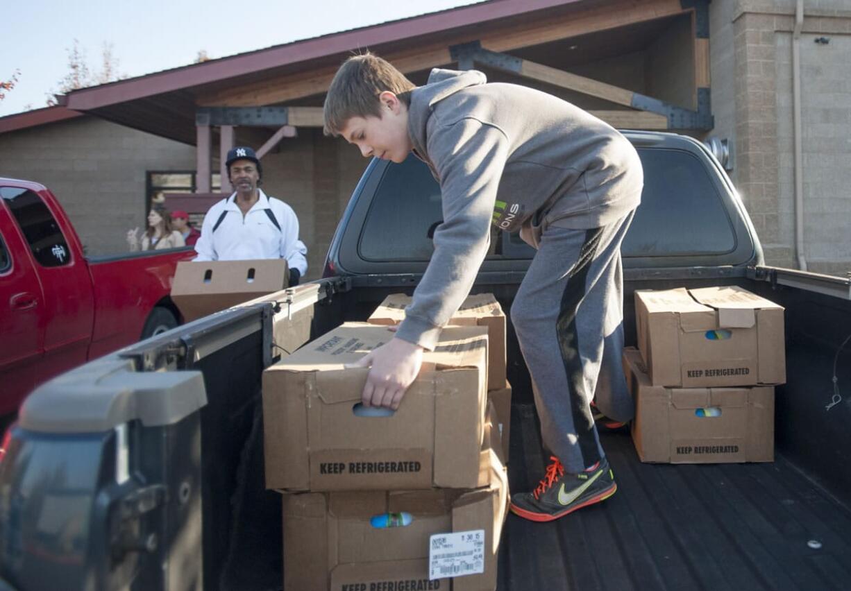 Cody Turner 13, right and Kenneth Bass packs turkeys into a truck to be delivered to Silver Star Elementary School on Monday. Donations of turkeys and other food items will provide Thanksgiving dinner for  dozens of low-income families in Clark County. Students at Sunset Elementary and Hudson&#039;s Bay High schools also received donations.