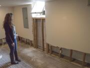 Debbie Hinesley surveys the damage water and mud from weekend storms wrought in the basement of her Greeley Street home in Camas.