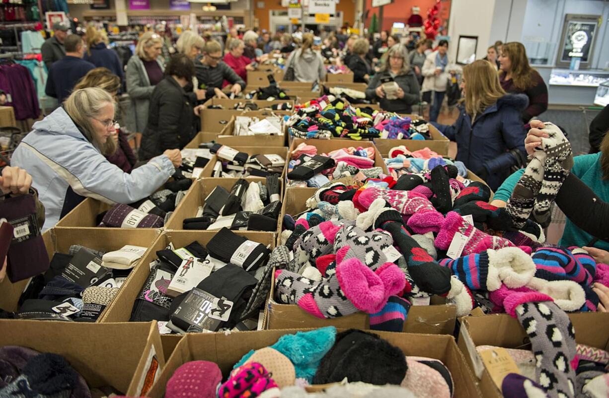 Customers sift through socks of all colors and styles at the Fred Meyer Fishers Landing store early on Black Friday. The traditional half-price sale on socks from 5 a.m. to 1 p.m. is a tradition for may local shoppers.