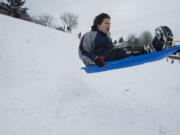 Matthew Bewick, 12, launches off a snow ramp while sledding at Franklin Elementary on Friday.