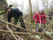 Jack Dojan and his daughter Haley Dojan, 11, work to clear a new forest trail along the side of Vancouver Lake.