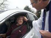 The Rev. Tom Warne provides a drive-up anointing of ashes to Gary Hatzenbeler on Wednesday outside of the Church of the Good Shepherd.