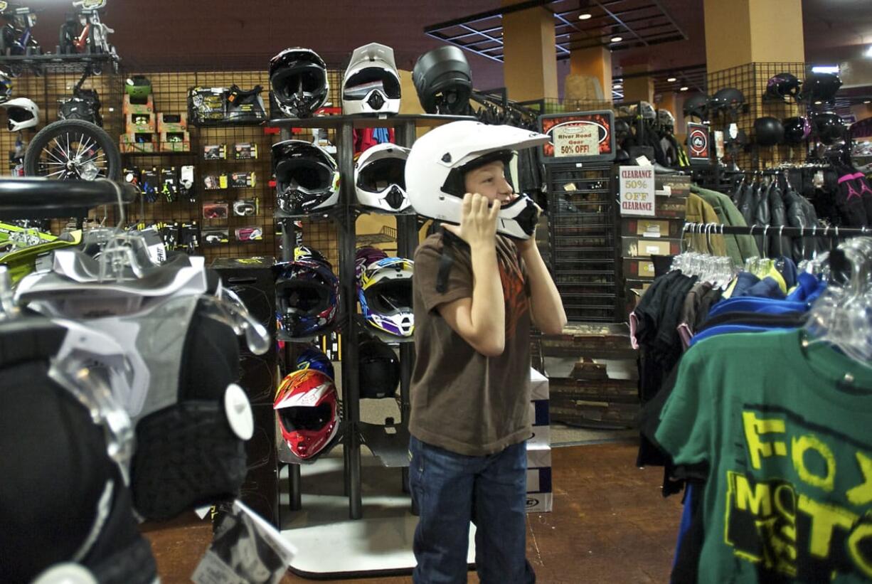 Conner Grant, 11, of Battle Ground tries on a helmet at Pro Caliber in Vancouver, one of three retail locations for the Vancouver-based company.