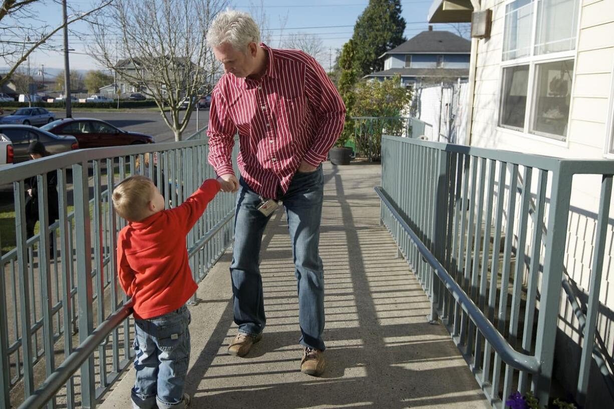 Wayne Garlington, executive director of Open House Ministries, bumps knuckles with resident Mathias Collinsworth, 3, outside the family shelter in downtown Vancouver.