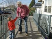 Wayne Garlington, executive director of Open House Ministries, bumps knuckles with resident Mathias Collinsworth, 3, outside the family shelter in downtown Vancouver.