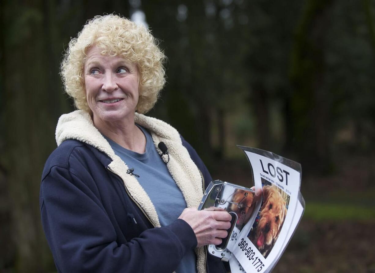 Cindy Koch, of Vashon Island, joins a group of volunteers Wednesday at the Gee Creek rest stop as they post fliers seeking Daisy, a terrier that went missing after a 28-vehicle crash on Interstate 5 earlier this month.