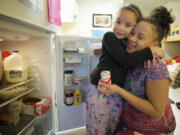 Taliah Litt, 6, left, hugs her mother Tiara Simms at their home at Open House Ministries.