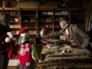 Volunteer John Barnhill educates visitors on pelts at the Indian Trade Shop and Dispensary at Fort Vancouver during the annual Christmas at the Fort event.