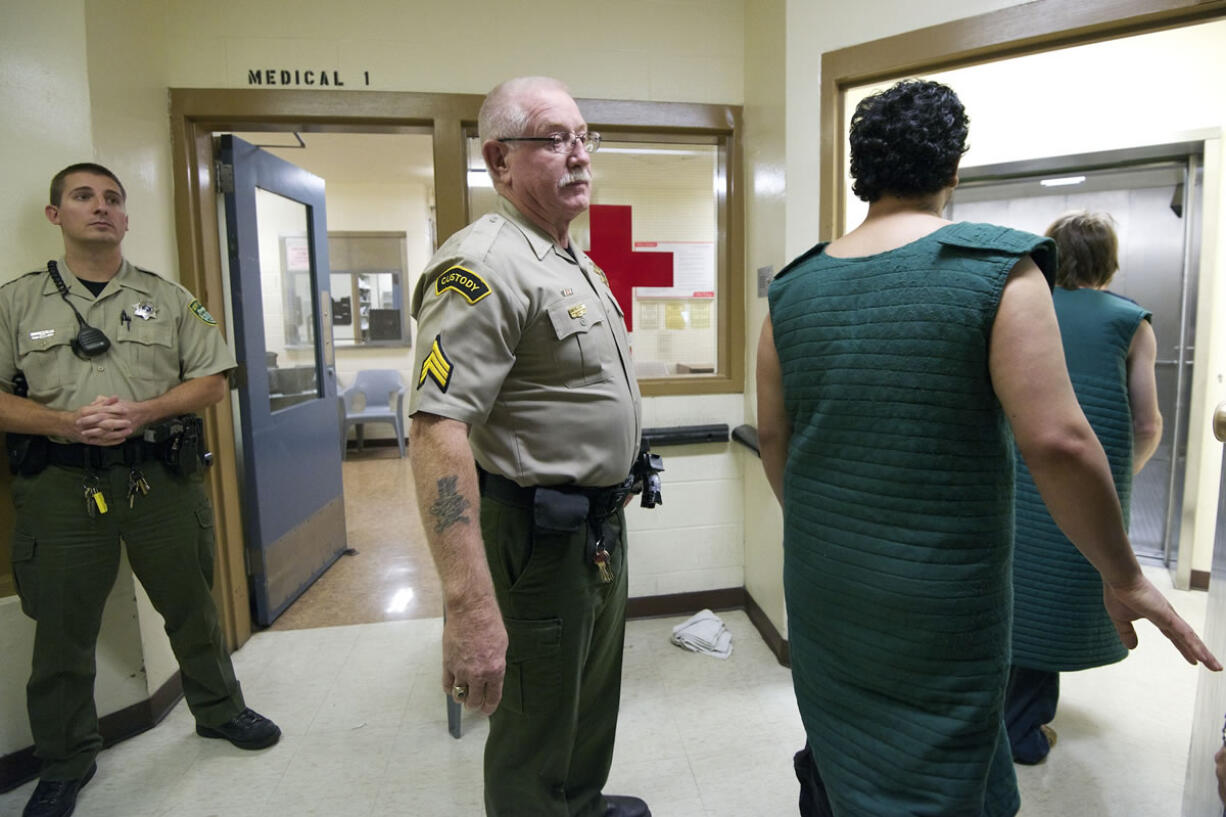 Corrections Sgt. Jack Huff, center, escorts inmates wearing suicide smocks to an elevator as they make their way to court from the Clark County Jail.