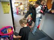 Battle Ground newcomer Stacy Pfeifer, 32, steers her children -- from left, Benjamin, 4, Caeden, 2, and Dalin, 1 -- through the North County Community Food Bank. Pfeifer said she and her husband are both disabled military veterans; on Nov.