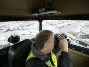 Neighbors On Watch volunteer Bob Kennedy monitors the parking lot at Westfield Vancouver mall from the Vancouver Police Skywatch observation tower Friday.