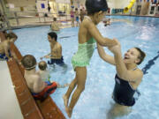 Swim instructor Kayla Weaver encourages Laelah Djourabchi, 5, to jump into the pool during a swim class Nov. 27 at the Marshall Community Center.